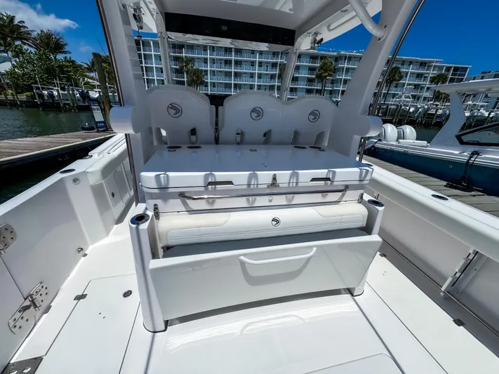  Yacht Photos Pics 2025 Edgewater 370CC boat interior with seating and storage, docked near waterfront buildings.