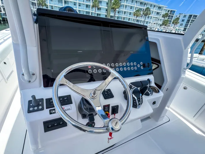  Yacht Photos Pics 2025 Edgewater 370CC helm with modern controls and dual displays, dockside view.