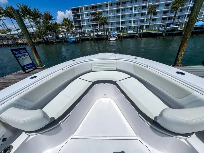  Yacht Photos Pics 2025 Edgewater 370CC boat with spacious seating, docked near waterfront buildings.