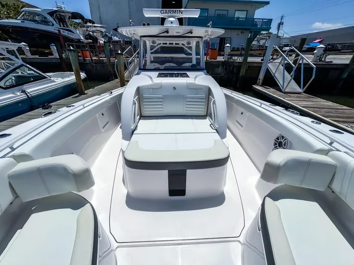  Yacht Photos Pics 2025 Edgewater 370CC boat with spacious seating and Garmin navigation system at a marina.