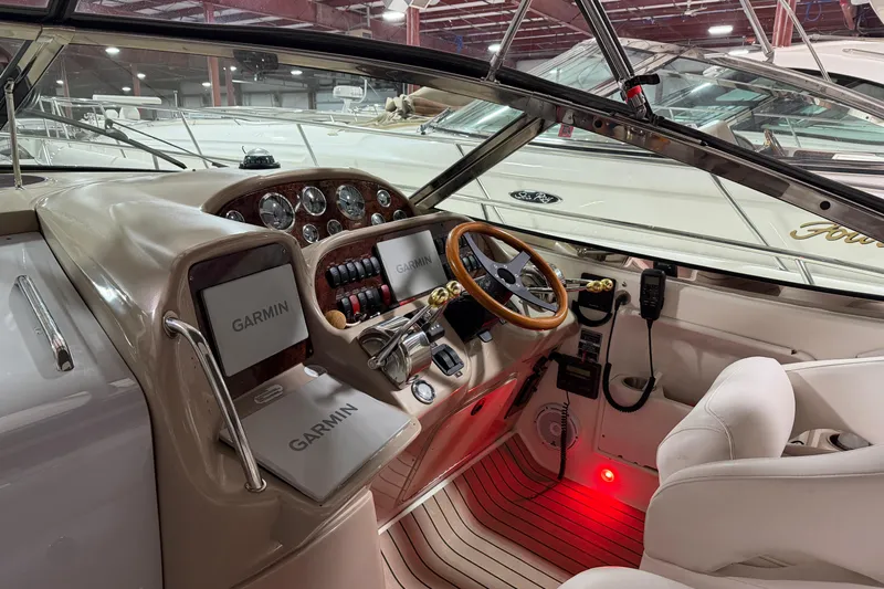 Good Juju Yacht Photos Pics 2005 Sea Ray 360 Sundancer helm with Garmin navigation, wood accents, and leather seating.