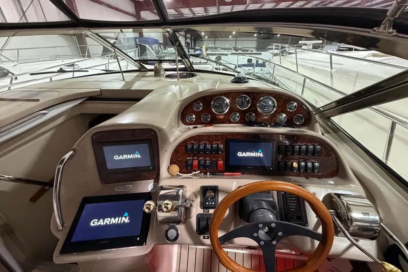 Good Juju Yacht Photos Pics 2005 Sea Ray 360 Sundancer helm with Garmin navigation displays and wooden steering wheel.