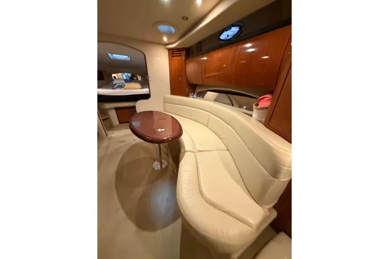 Good Juju Yacht Photos Pics Luxurious interior of 2005 Sea Ray 360 Sundancer yacht with curved seating and wooden table.