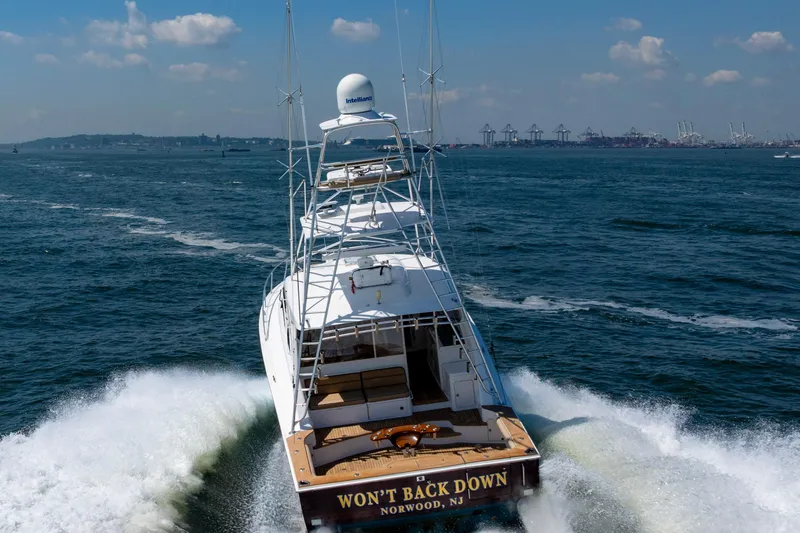  Yacht Photos Pics 2012 Cabo 44 Hardtop Express yacht cruising on open water, rear view.