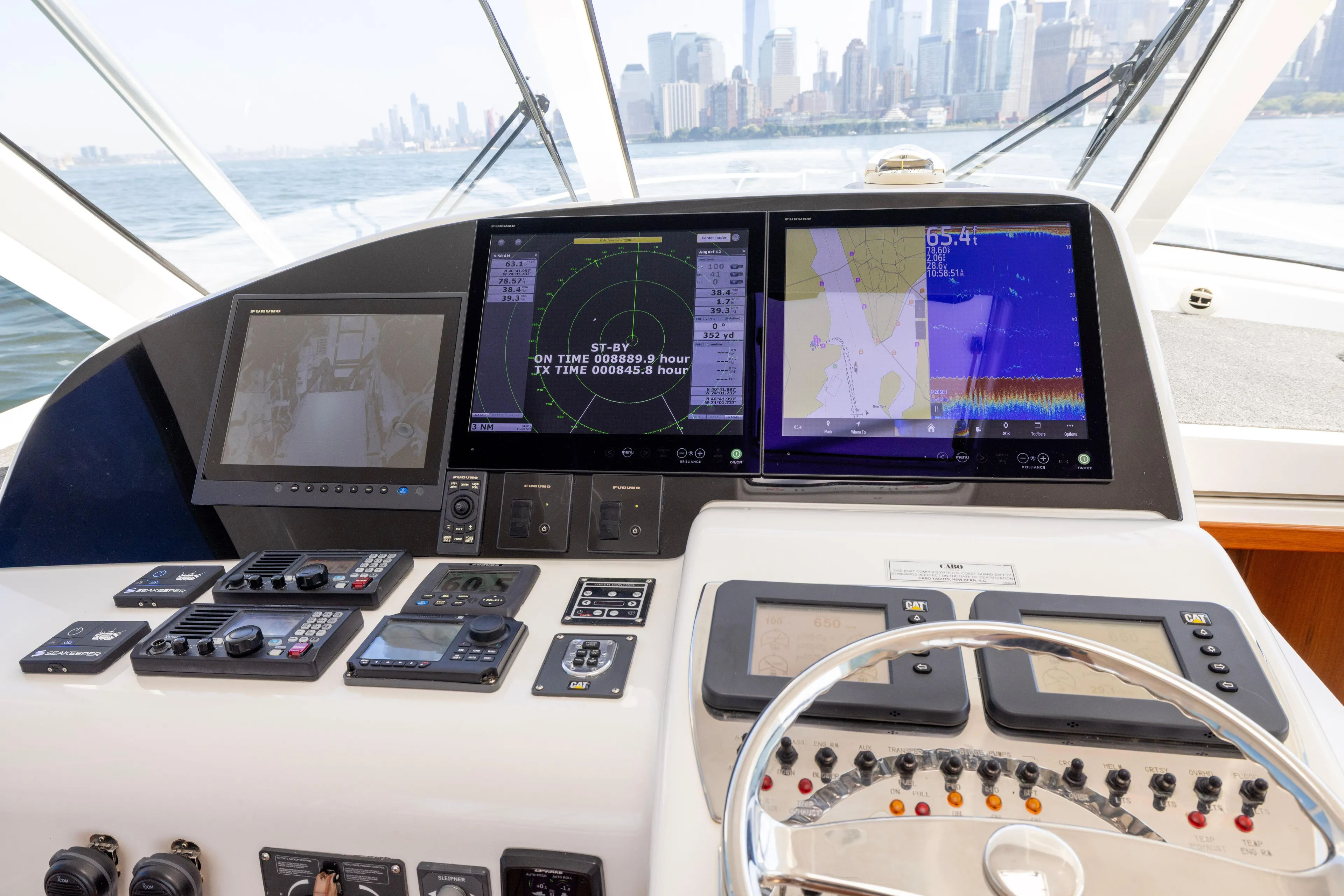  Yacht Photos Pics Control panel of 2012 Cabo 44 Hardtop Express yacht with navigation screens and steering wheel.