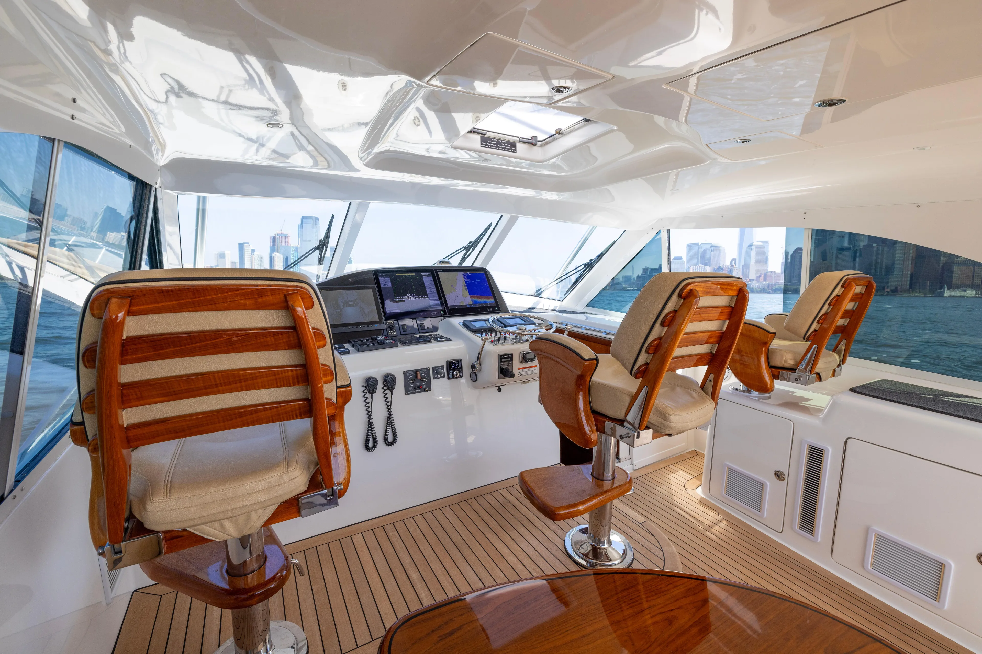  Yacht Photos Pics Luxurious 2012 Cabo 44 Hardtop Express yacht interior with helm and wooden seating.