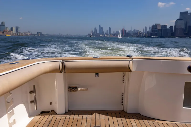  Yacht Photos Pics 2012 Cabo 44 Hardtop Express cruising with city skyline in the background.