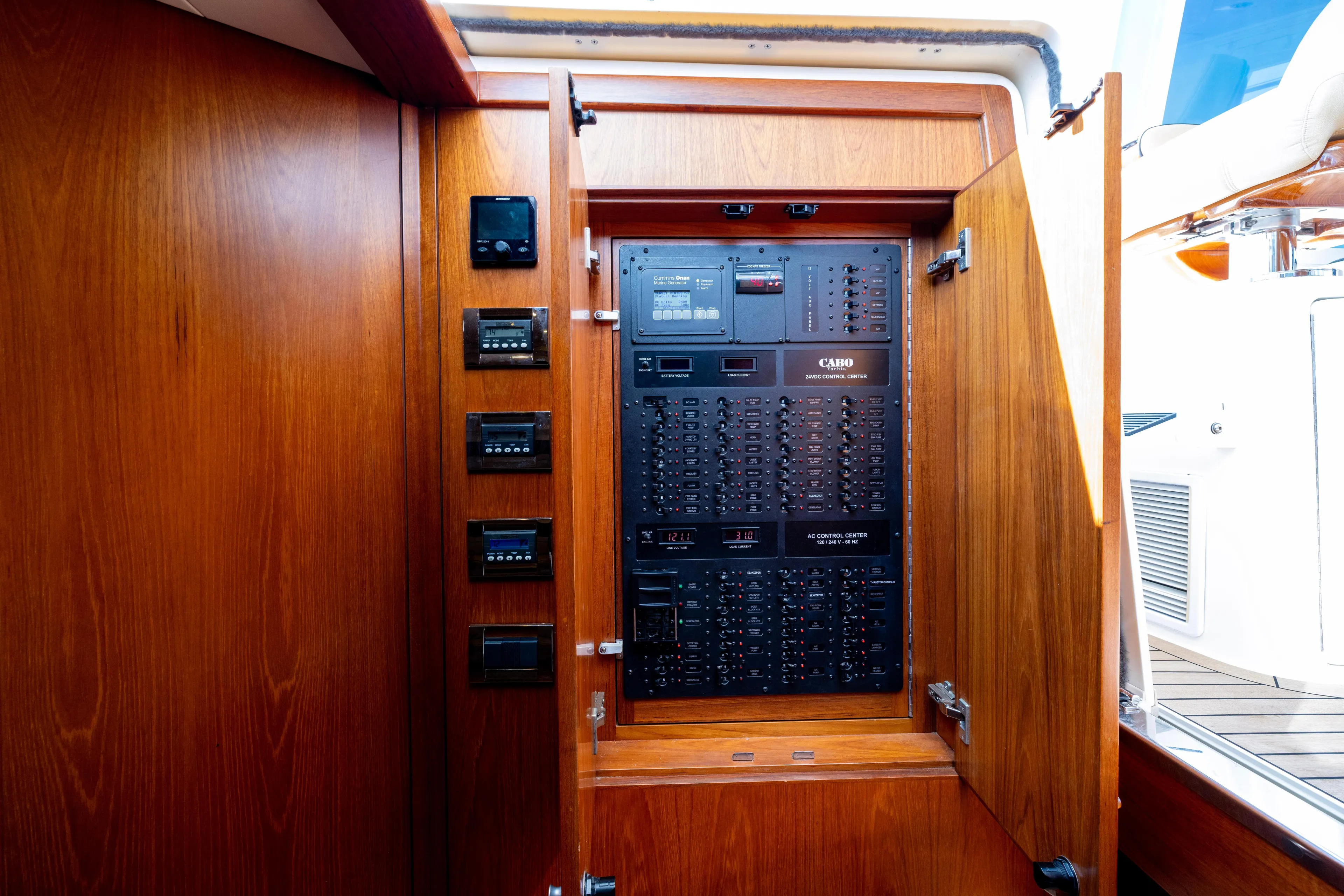  Yacht Photos Pics Electrical control panel inside 2012 Cabo 44 Hardtop Express yacht, featuring wooden cabinetry.