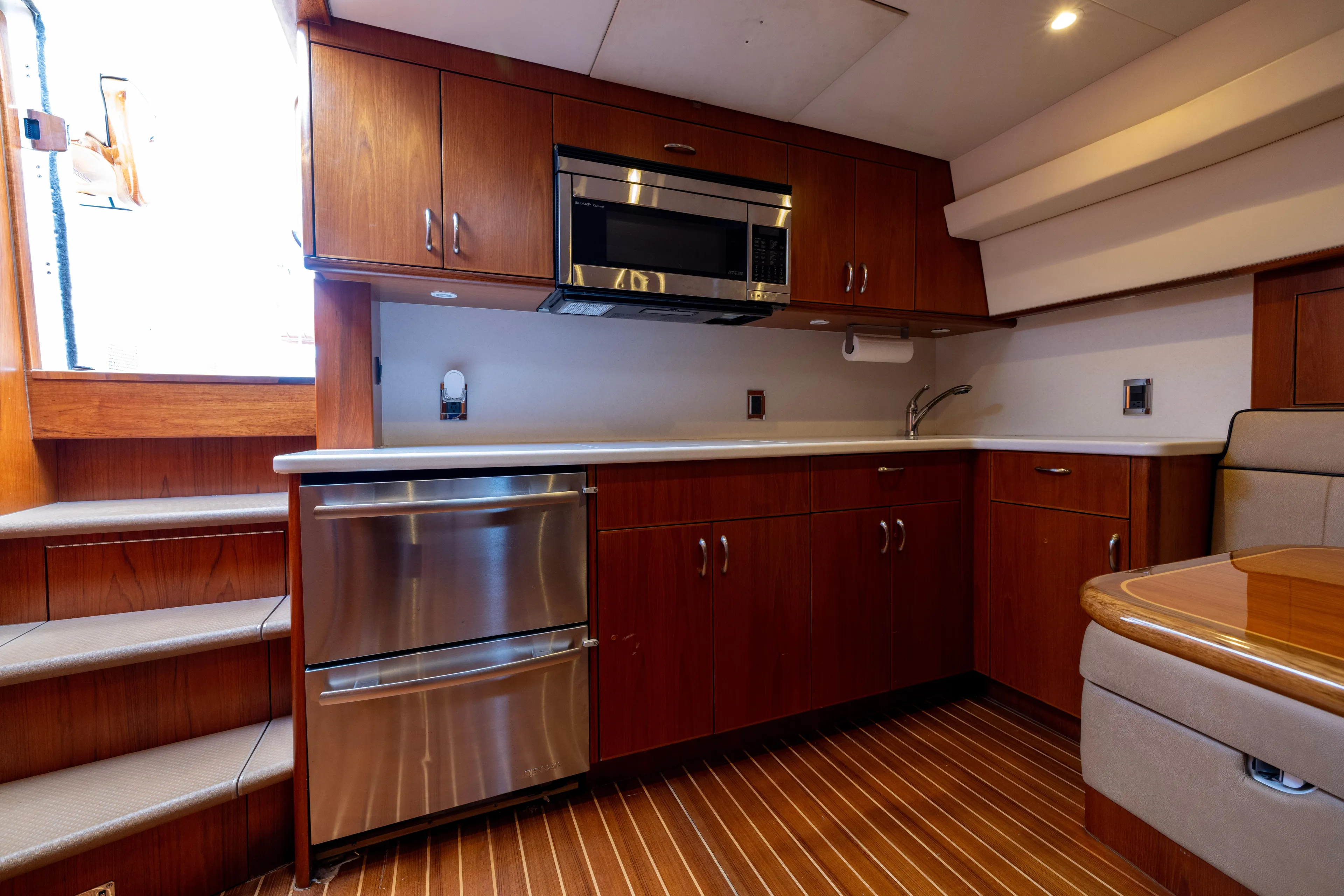  Yacht Photos Pics Luxurious 2012 Cabo 44 Hardtop Express yacht kitchen with wood cabinetry and stainless steel appliances.