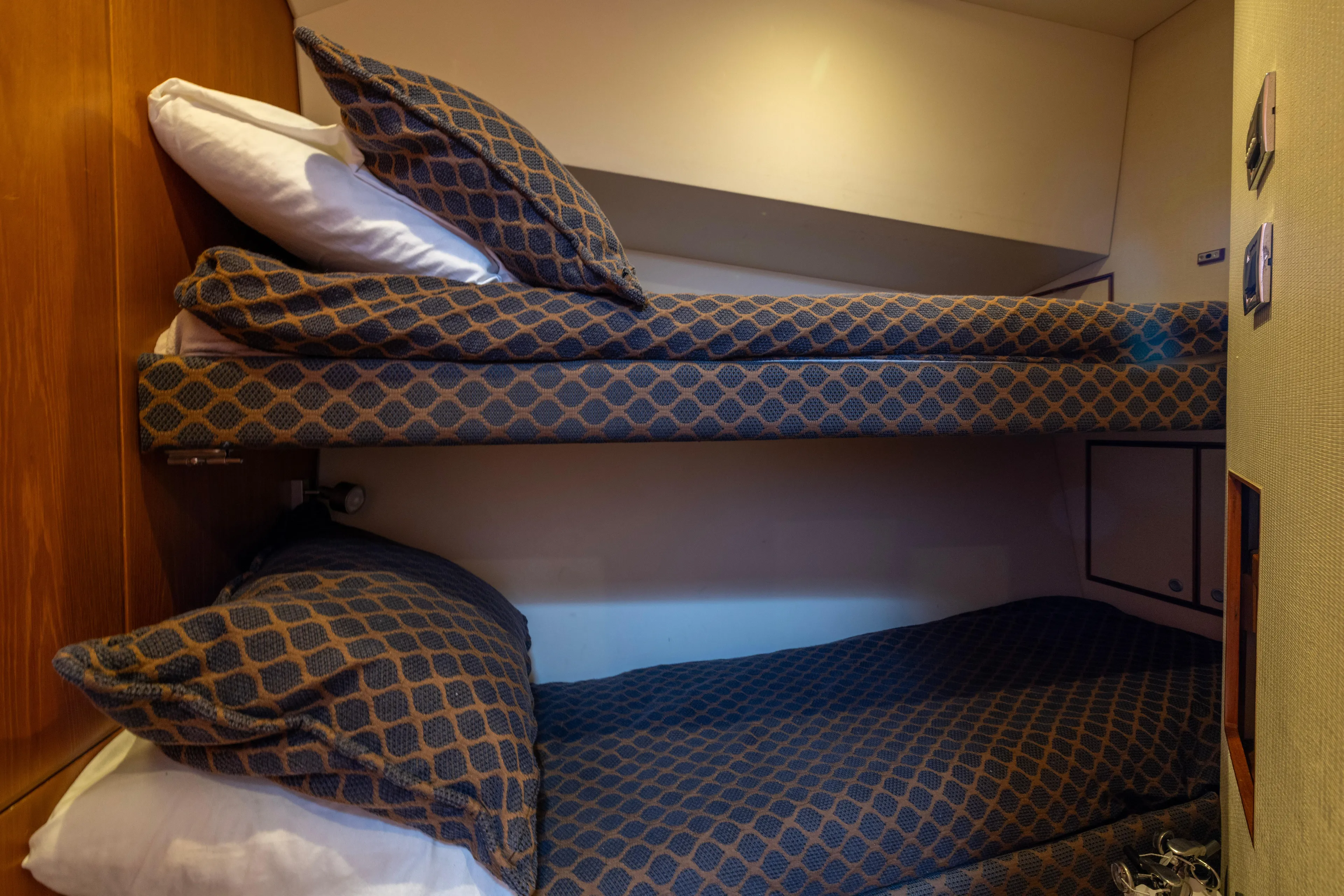  Yacht Photos Pics Bunk beds in 2012 Cabo 44 Hardtop Express yacht cabin, featuring patterned bedding.