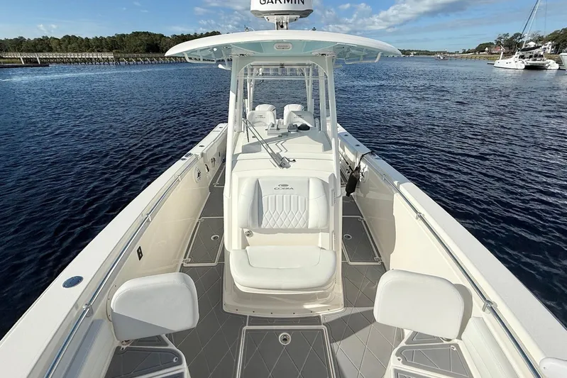  Yacht Photos Pics 2020 Cobia 301 Center Console boat on calm water, featuring spacious deck and seating.