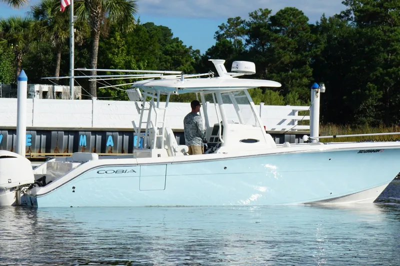  Yacht Photos Pics 2020 Cobia 301 Center Console boat docked near palm trees and water.