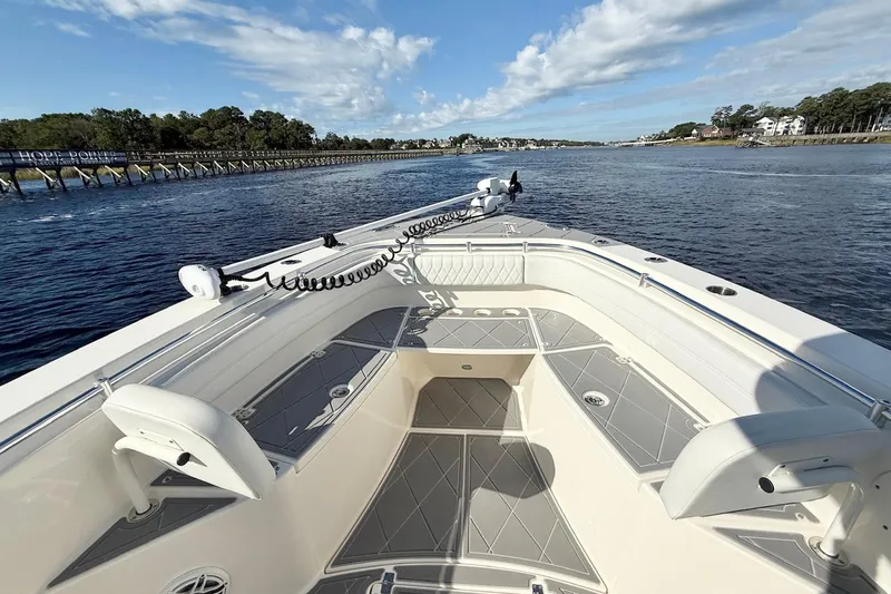  Yacht Photos Pics 2020 Cobia 301 Center Console boat on a scenic waterway under a blue sky.