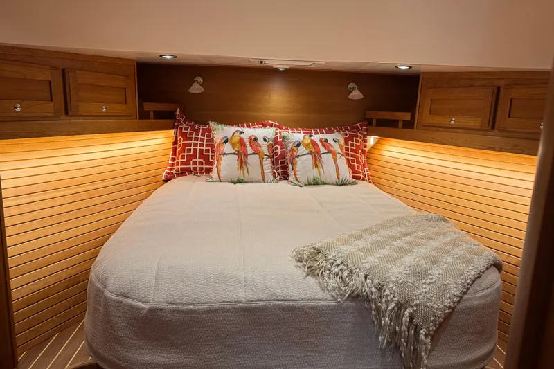 Dot's Deal Yacht Photos Pics Cozy bedroom in 2023 Sabre 48 Salon Express yacht with decorative pillows and warm lighting.