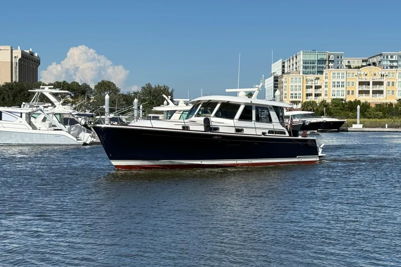 Haggis Xx Yacht Photos Pics 2017 Sabre 48 Salon Express yacht cruising in a marina with buildings in the background.