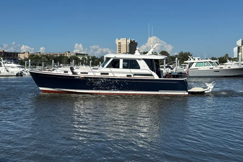 Haggis Xx Yacht Photos Pics 2017 Sabre 48 Salon Express yacht cruising in a marina under clear blue skies.