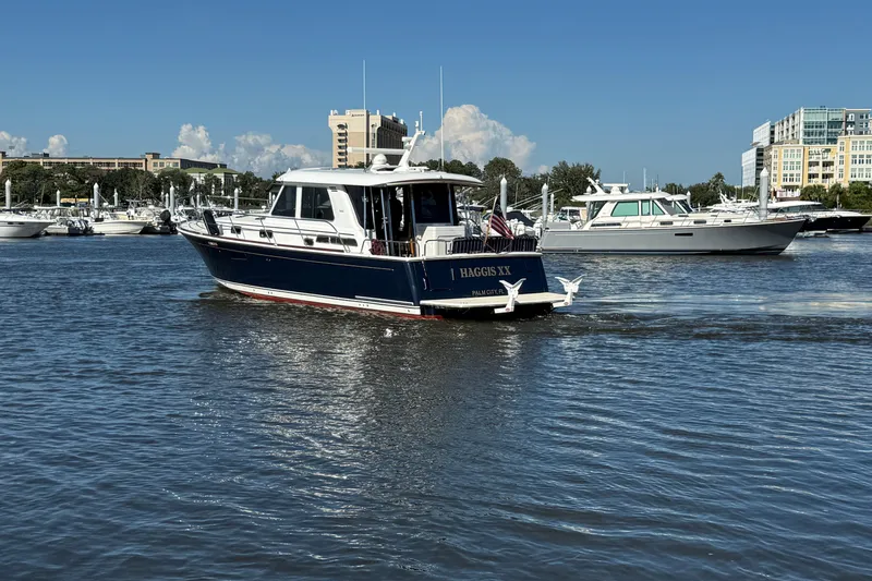 Haggis Xx Yacht Photos Pics 2017 Sabre 48 Salon Express yacht cruising in a marina with other boats and buildings in the background.