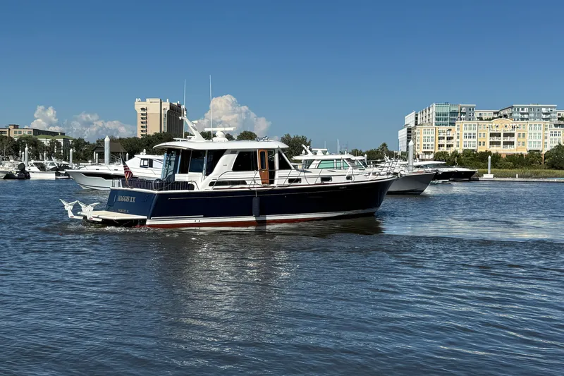 Haggis Xx Yacht Photos Pics 2017 Sabre 48 Salon Express yacht cruising in a marina with buildings in the background.
