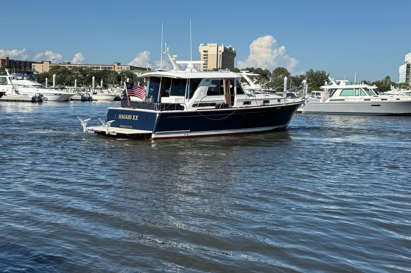 Haggis Xx Yacht Photos Pics 2017 Sabre 48 Salon Express yacht on water, with marina and buildings in background.