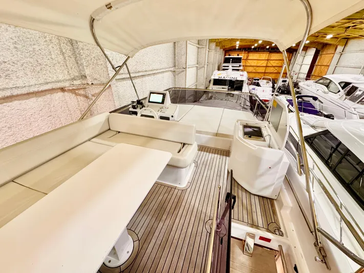 Time To Fly Yacht Photos Pics 2022 Ferretti Yachts 550 interior with seating and navigation equipment in a showroom.