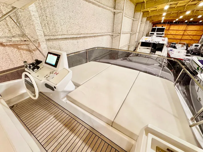 Time To Fly Yacht Photos Pics 2022 Ferretti Yachts 550 interior with helm station and spacious seating in a well-lit showroom.