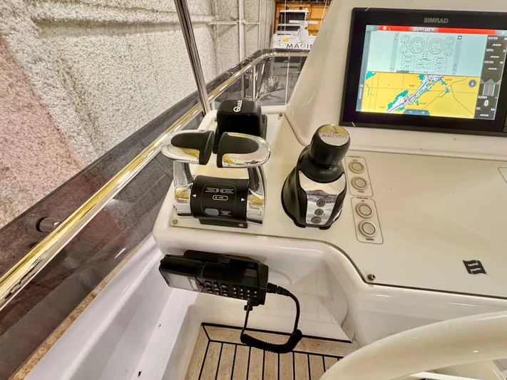 Time To Fly Yacht Photos Pics Cockpit controls of a 2022 Ferretti Yachts 550, featuring navigation screen and communication device.