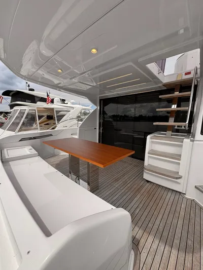 Time To Fly Yacht Photos Pics 2022 Ferretti Yachts 550 deck with wooden table and modern staircase.
