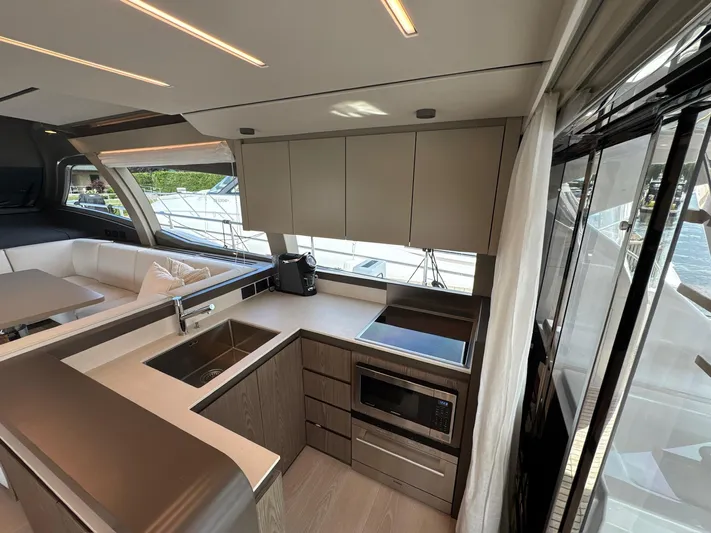 Time To Fly Yacht Photos Pics Modern kitchen interior of 2022 Ferretti Yachts 550, featuring sleek cabinetry and appliances.