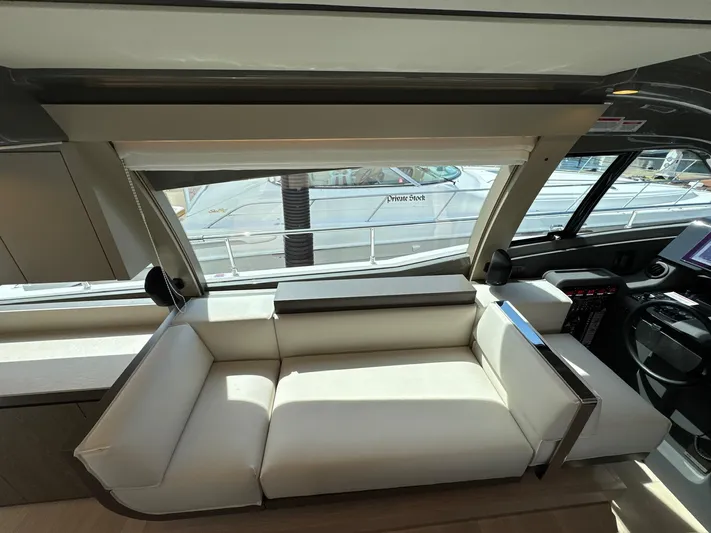 Time To Fly Yacht Photos Pics Interior of 2022 Ferretti Yachts 550, featuring a sleek white sofa and modern design elements.