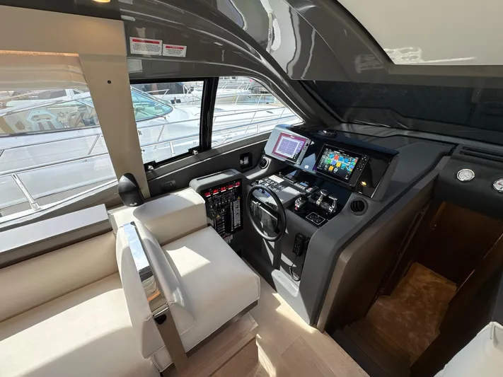 Time To Fly Yacht Photos Pics Interior cockpit of 2022 Ferretti Yachts 550, featuring modern navigation equipment and luxurious seating.