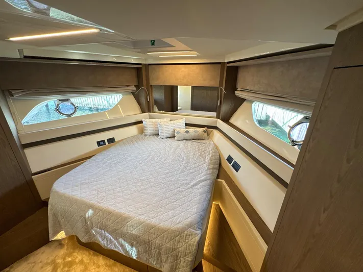 Time To Fly Yacht Photos Pics Luxurious bedroom interior of 2022 Ferretti Yachts 550 with elegant bedding and wood accents.