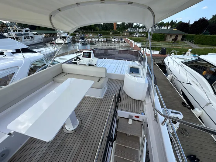 Time To Fly Yacht Photos Pics Luxurious 2022 Ferretti Yachts 550 flybridge with elegant seating and modern helm station.