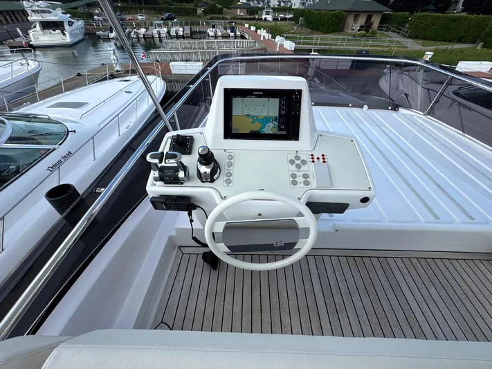 Time To Fly Yacht Photos Pics Helm station of 2022 Ferretti Yachts 550 with navigation controls and display.