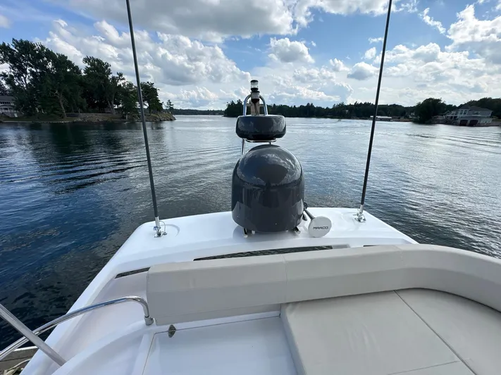 Time To Fly Yacht Photos Pics Ferretti Yachts 550, 2022 model, cruising on a serene lake under a partly cloudy sky.