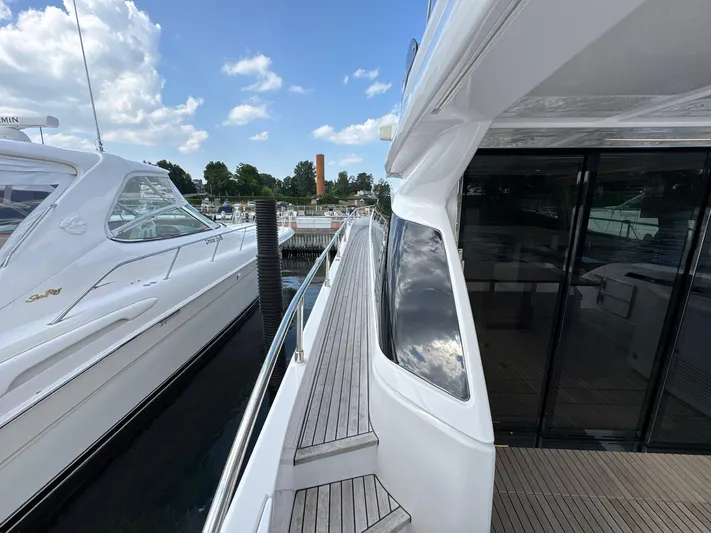 Time To Fly Yacht Photos Pics 2022 Ferretti Yachts 550 docked, showcasing sleek design and modern features under a blue sky.