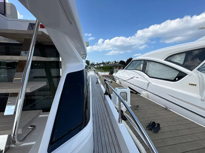 Time To Fly Yacht Photos Pics 2022 Ferretti Yachts 550 docked, showcasing sleek design and modern features under a clear sky.