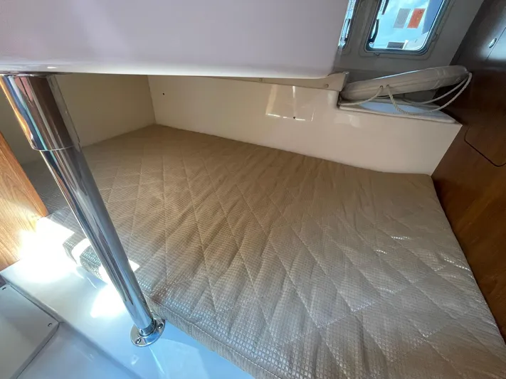  Yacht Photos Pics 2012 Pursuit OS 315 Offshore cabin interior with cushioned bed and metal support pole.