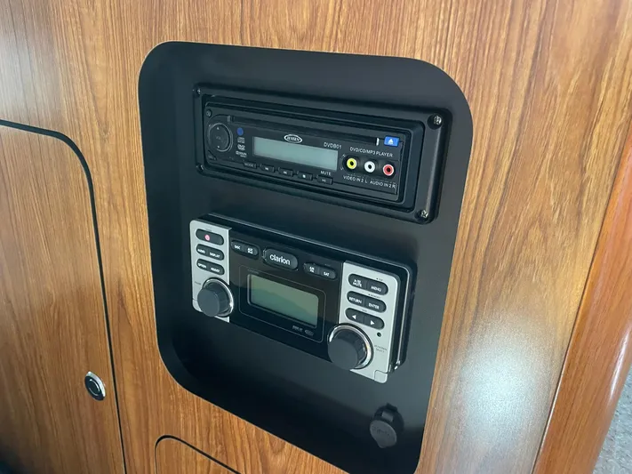  Yacht Photos Pics Audio system in 2012 Pursuit OS 315 Offshore boat, featuring wood paneling and control interface.