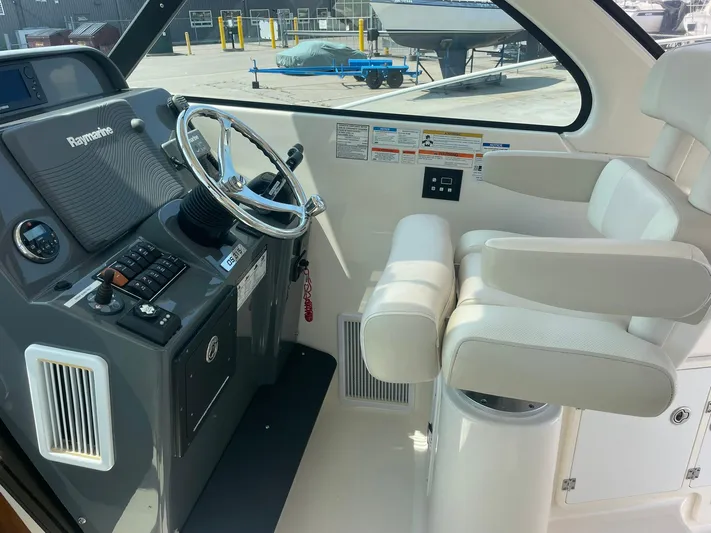  Yacht Photos Pics 2012 Pursuit OS 315 Offshore helm with Raymarine electronics and white captain's chair.