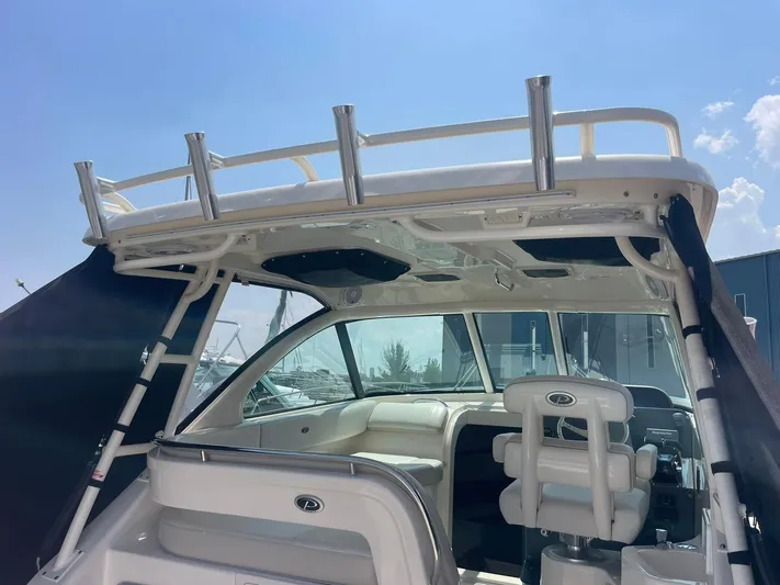  Yacht Photos Pics 2012 Pursuit OS 315 Offshore boat interior with seating and rod holders under a clear sky.