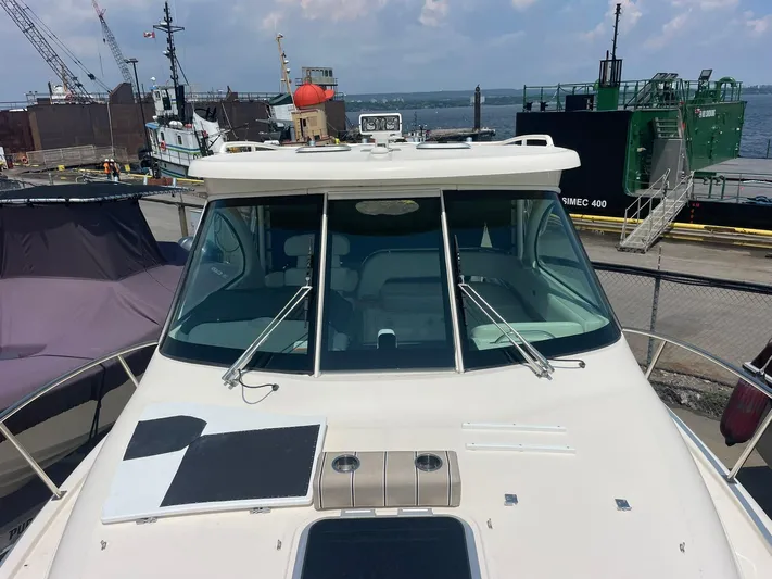  Yacht Photos Pics 2012 Pursuit OS 315 Offshore boat docked at a busy harbor with industrial ships.