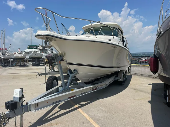  Yacht Photos Pics 2012 Pursuit OS 315 Offshore boat on trailer at marina under blue sky.