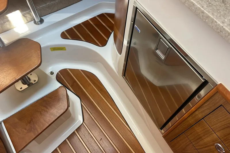  Yacht Photos Pics 2012 Pursuit OS 315 Offshore interior with wood flooring and stainless steel refrigerator.