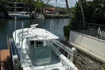  Yacht Photos Pics 2021 Yellowfin 39 boat docked by a scenic waterfront with lush greenery.