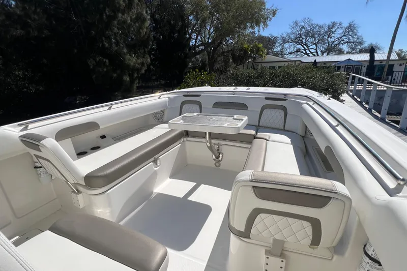  Yacht Photos Pics 2022 World Cat 280 CC-X boat interior with seating and table, surrounded by trees.