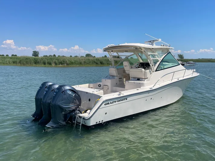  Yacht Photos Pics 2022 Grady-White Express 370 boat with triple outboard motors on calm water.