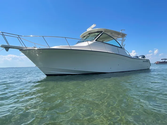  Yacht Photos Pics 2022 Grady-White Express 370 boat on clear water under a bright blue sky.