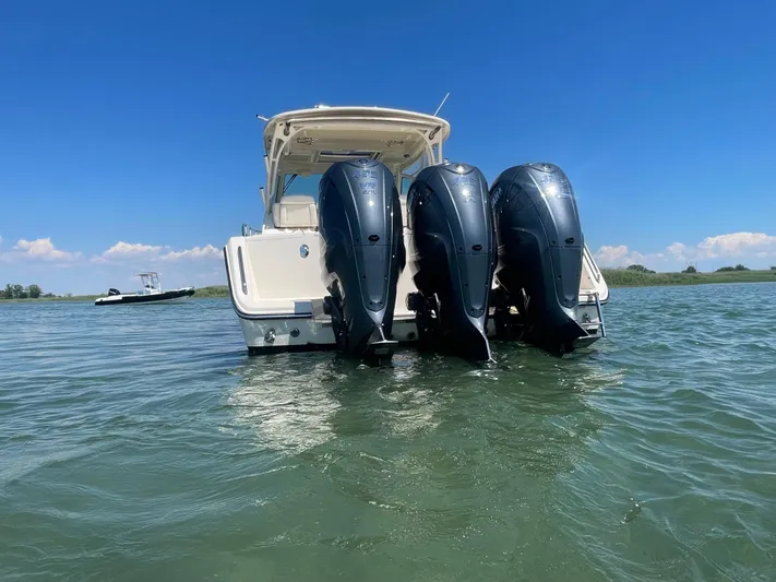  Yacht Photos Pics 2022 Grady-White Express 370 boat with triple outboard engines on water.