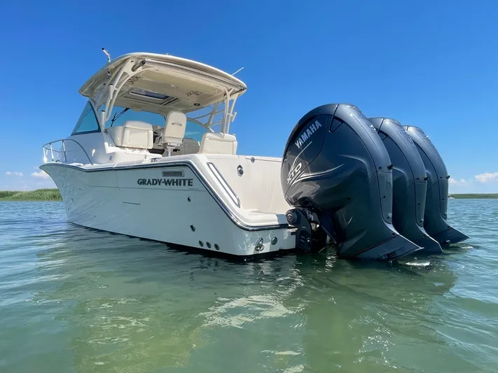  Yacht Photos Pics 2022 Grady-White Express 370 boat with triple Yamaha engines on clear water.