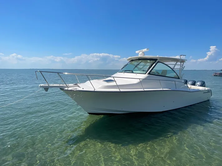  Yacht Photos Pics 2022 Grady-White Express 370 boat anchored in clear, calm waters under a blue sky.
